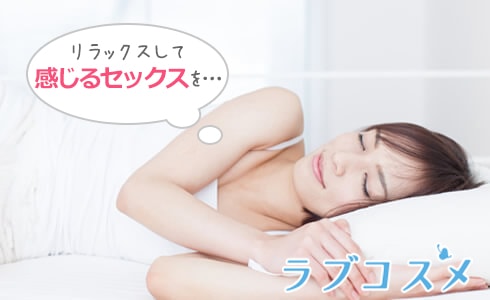 枕を抱えて微笑む女性