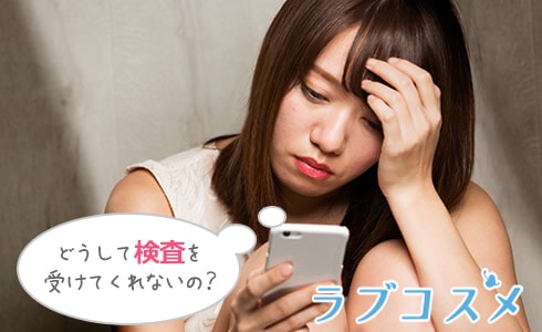 スマホを見て考え込む女性